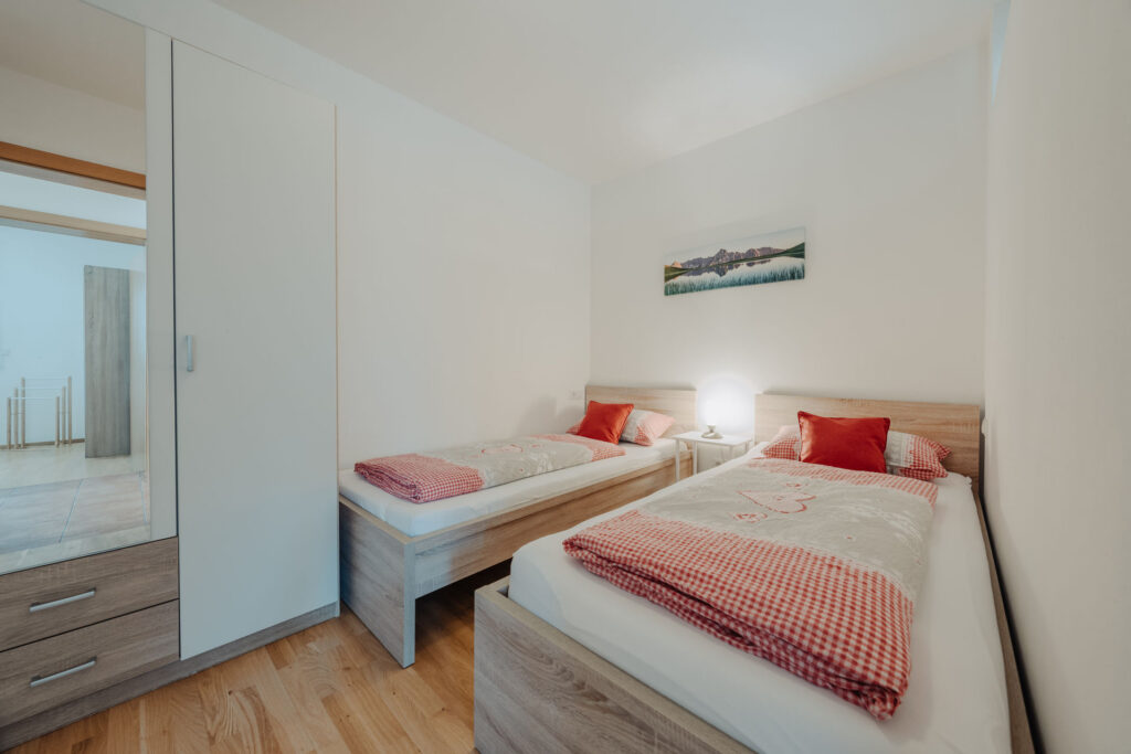 modernes helles Schlafzimmer mit 2 Einzelbetten und Schlafzimmerschrank
