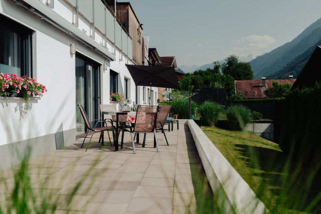 Helle moderne Terrasse mit Sonnenschirm und Terrassenmöbeln